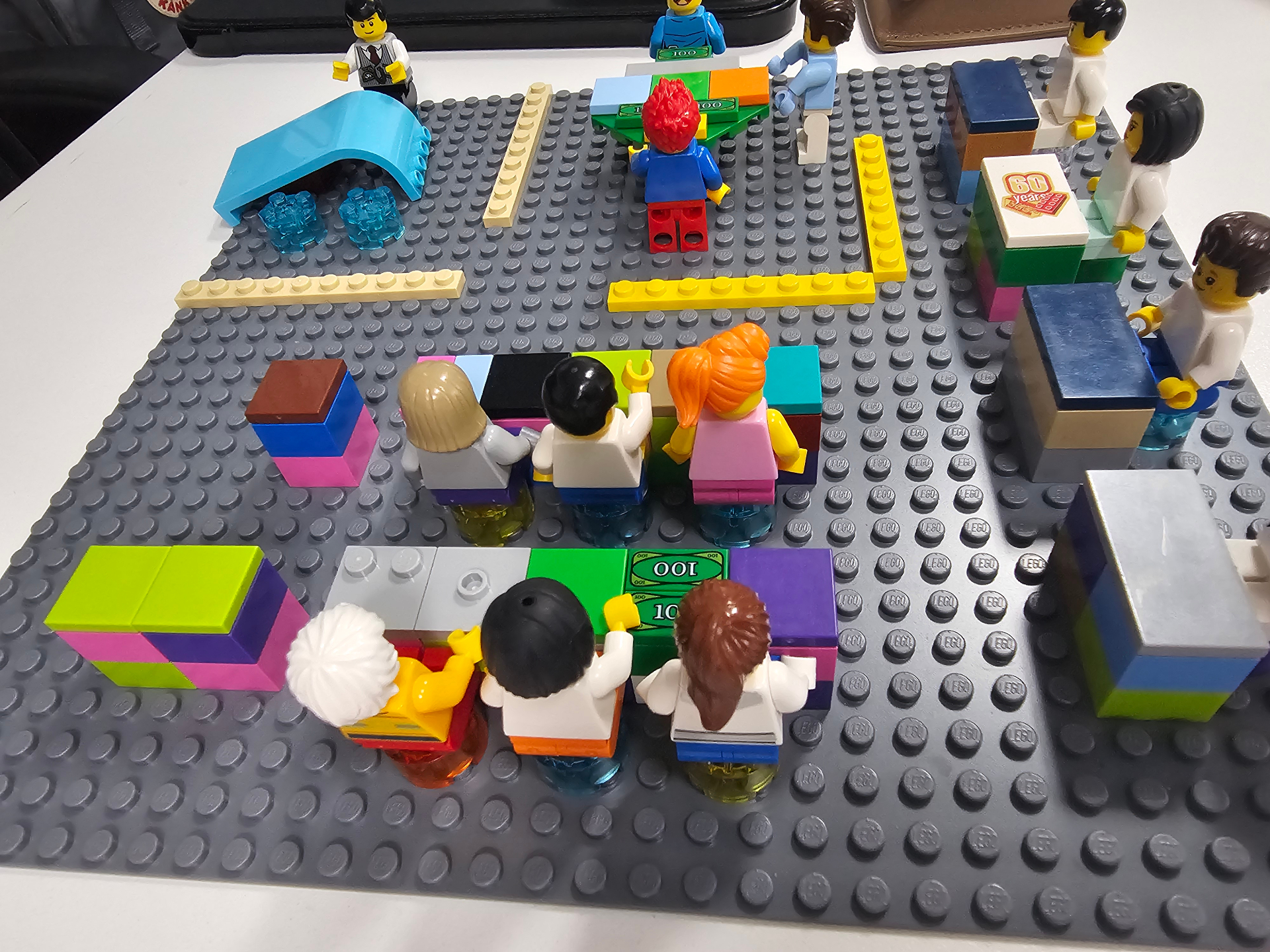 Cenário LEGO com minifigs em torno de mesa simbolizando equipe e estratégia