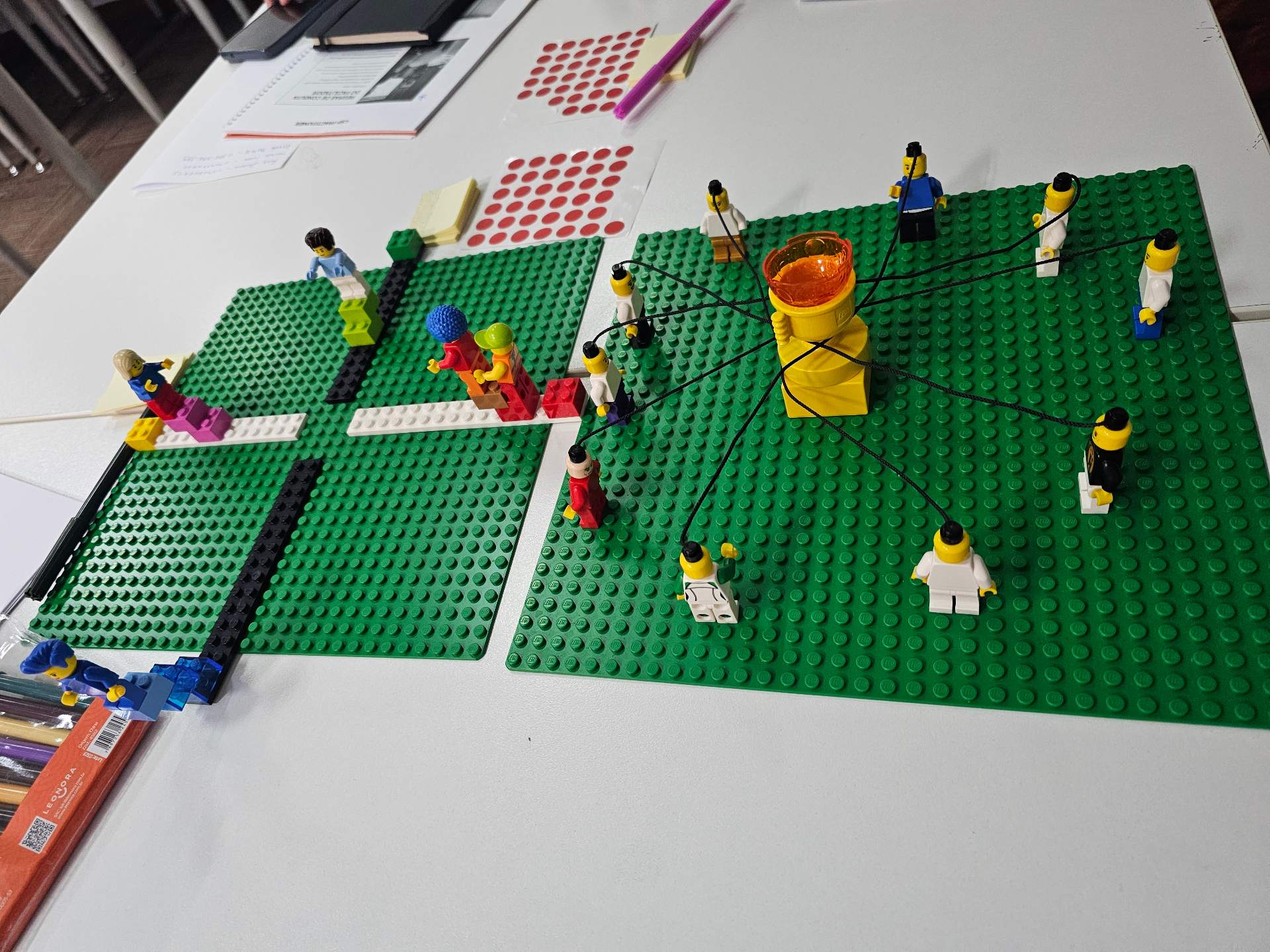 Equipe LEGO conectada por fios a um centro comum representando alinhamento